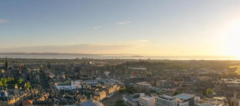 Aerial picture of the city of Edinburgh above the University's Central Campus, taken on a sunny morning. Arthur's Seat can be seen in the distance.